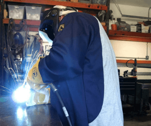 Picture of a welder wearing a welding jacket.