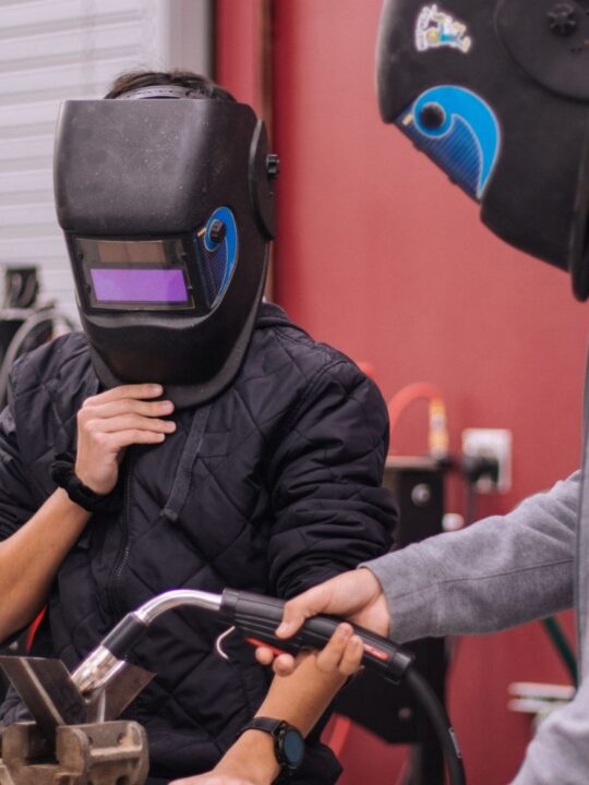 Picture of students working on their welding degree,